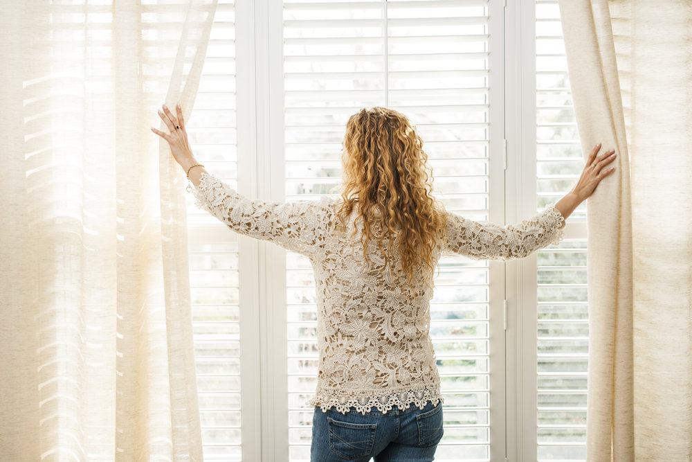 Woman opening shutters